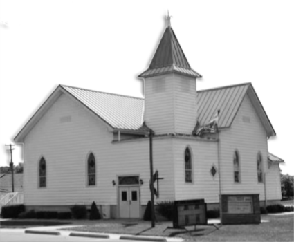 Picture of Juddville United Methodist Church in black and white. Features stained glass windows and wide stocky steeple.